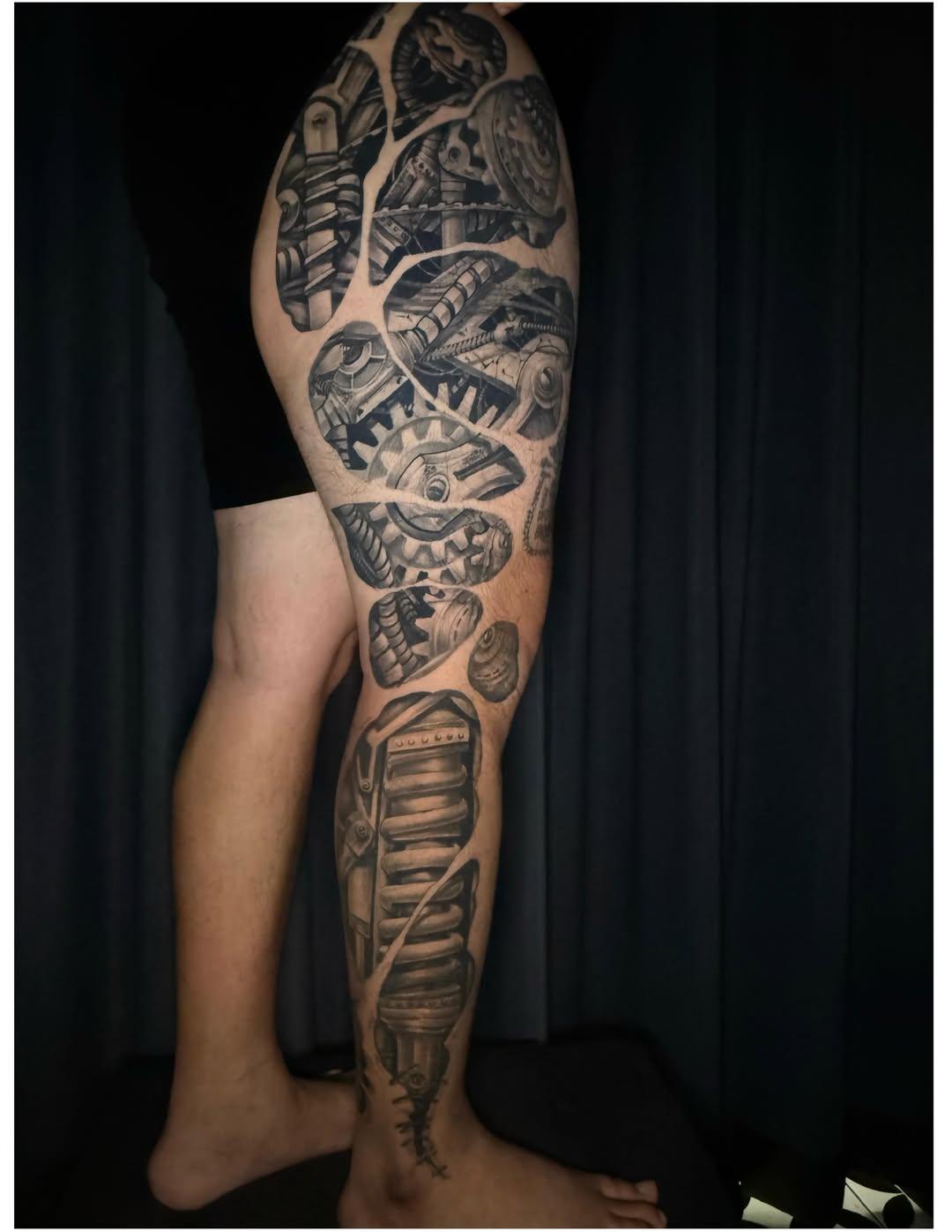 Black and grey biomechanical full leg tattoo